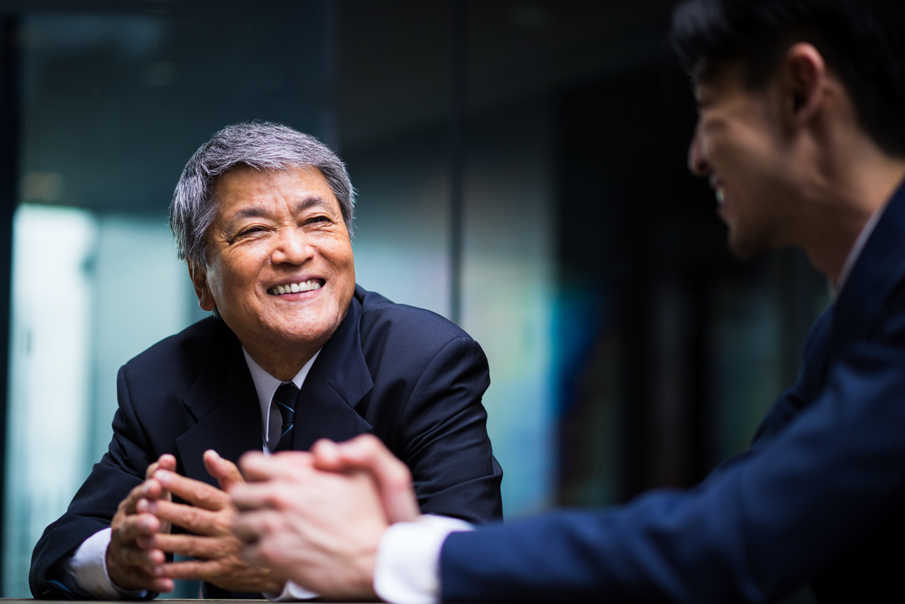 image of two men in business suites smiling 